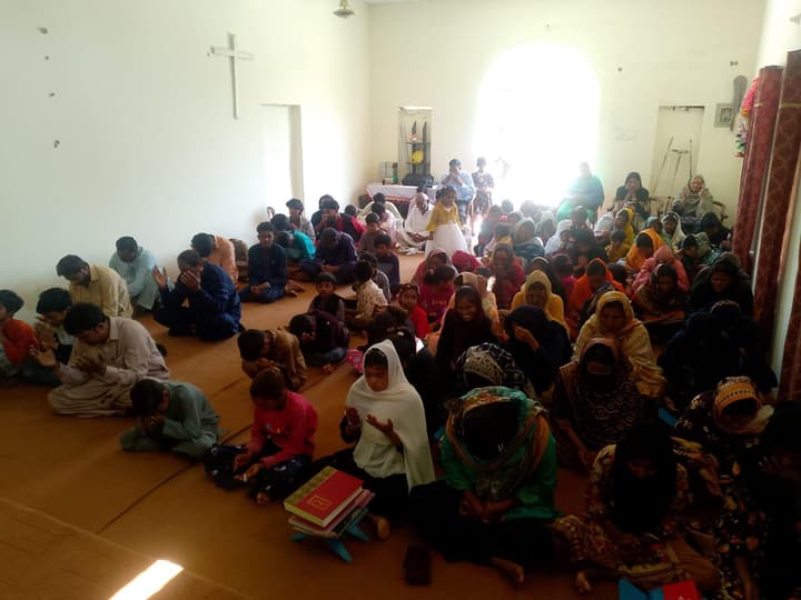 A large group of women and children gathered at an outreach meeting in Pakistan.